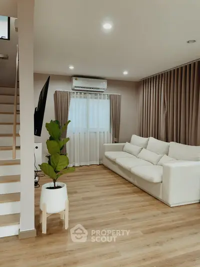 Modern living room with cozy white sofa and stylish wooden flooring