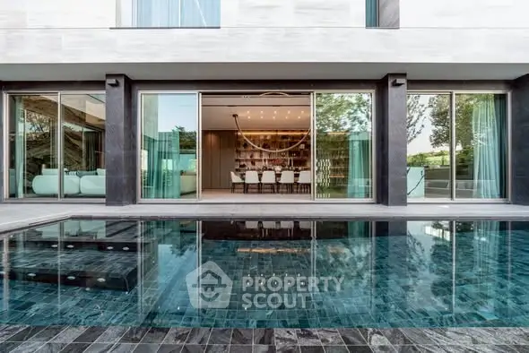 Luxurious modern home with stunning poolside view and elegant interior design.