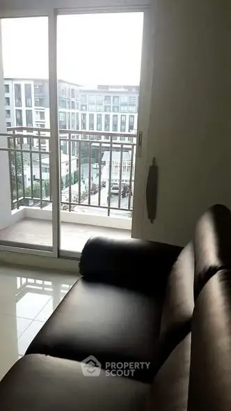 Modern apartment with balcony view and sleek leather sofa