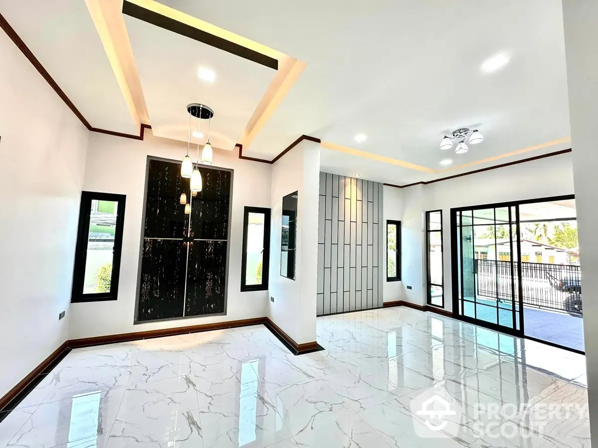 Spacious living room with high-gloss marble flooring, elegant ceiling design, and ample natural light from large windows and glass doors leading to an outdoor area.