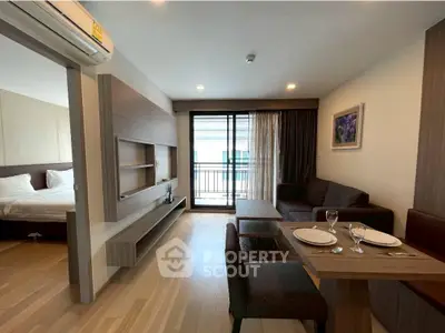 Modern living room with dining area and balcony access in a stylish apartment.