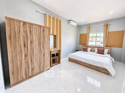 Spacious modern bedroom with wooden furniture and large window