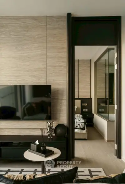Modern living room with sleek TV setup and view into stylish bedroom