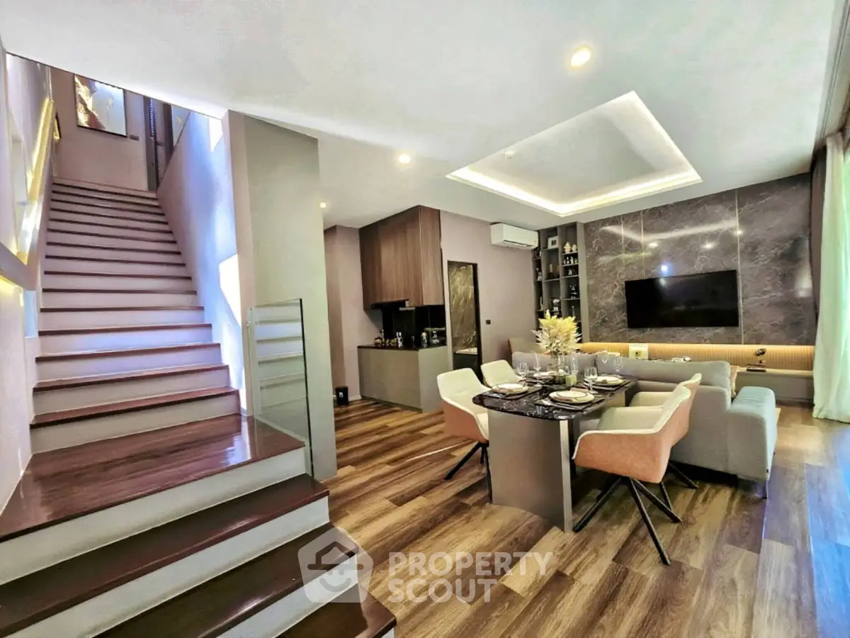 Modern living room with open layout, stylish decor, and elegant staircase in a contemporary home.