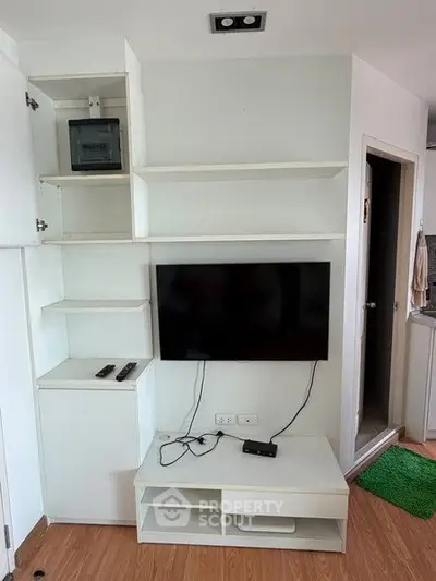 Modern living room with wall-mounted TV and sleek white shelving unit