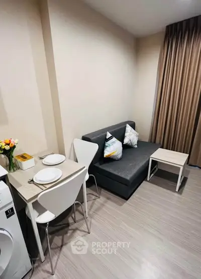 Cozy living room with modern decor and dining area in a stylish apartment.