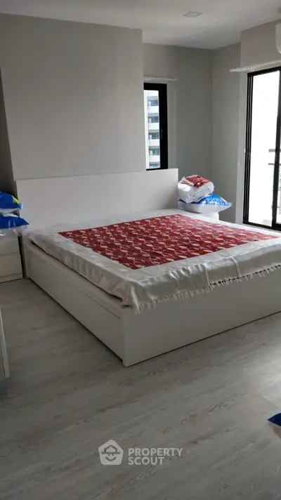 Modern bedroom with stylish bed and natural light, perfect for urban living.