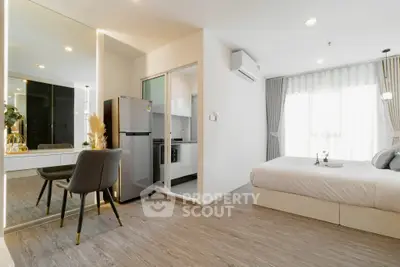 Modern studio apartment with sleek kitchen and cozy bedroom, featuring elegant decor and natural light.