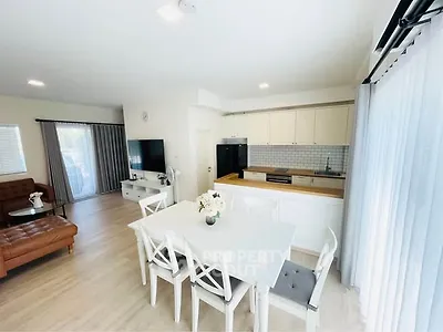 Bright open-plan living room and kitchen with modern decor and natural light.