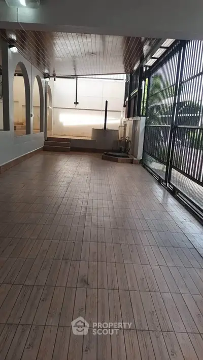 Spacious covered patio with tiled flooring and open design, perfect for outdoor gatherings.