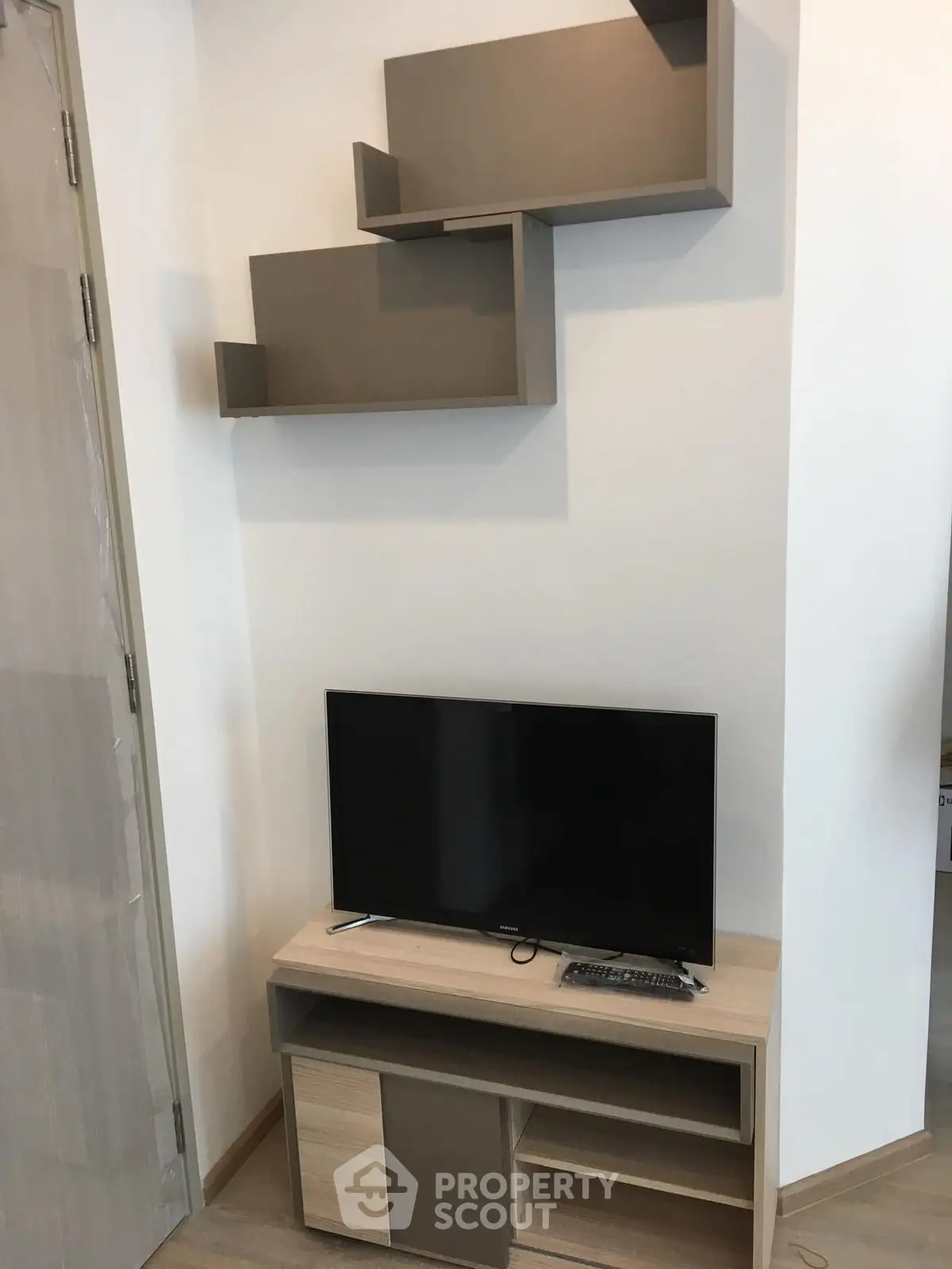 Modern living room with sleek TV stand and wall-mounted shelves
