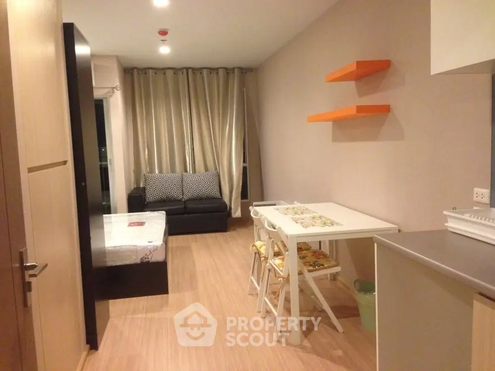 Modern studio apartment with cozy living area and dining space, featuring wooden flooring and stylish decor.