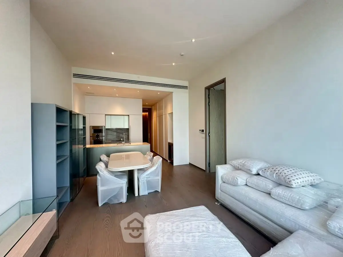 Modern living room with sleek furniture and open kitchen layout in a contemporary apartment.