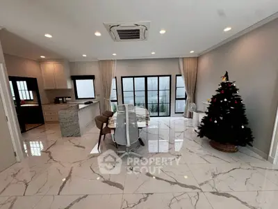 Spacious modern living room with marble flooring and Christmas tree, perfect for festive gatherings.