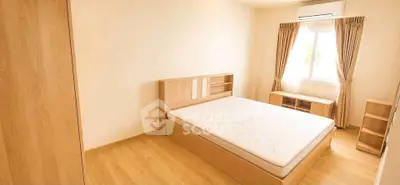 Spacious bedroom with natural light and wooden furniture, perfect for a cozy retreat.