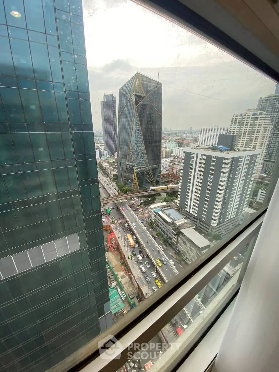 Stunning cityscape view from a high-rise building window, showcasing modern architecture and bustling streets.
