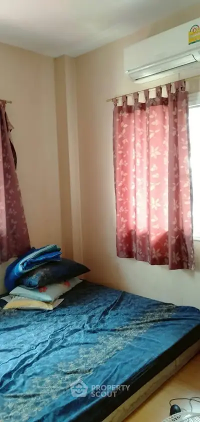 Cozy bedroom with floral curtains and air conditioning unit