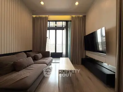 Modern living room with large TV and cozy sofa, featuring floor-to-ceiling windows and elegant curtains.