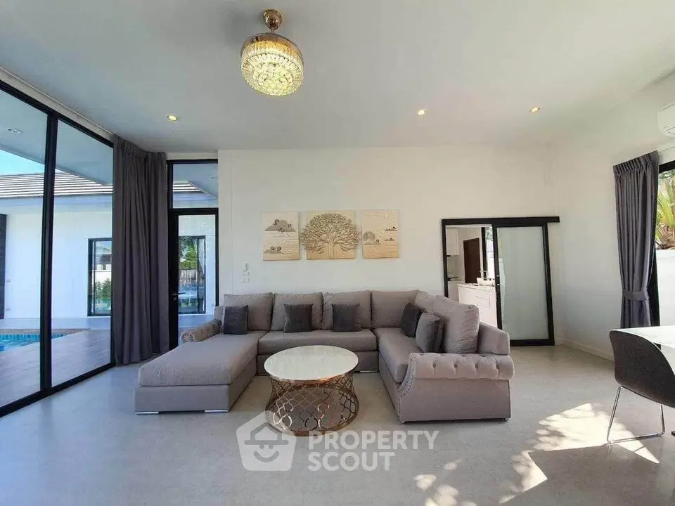 Luxurious living room with elegant sofa and modern decor, featuring large windows and natural light.