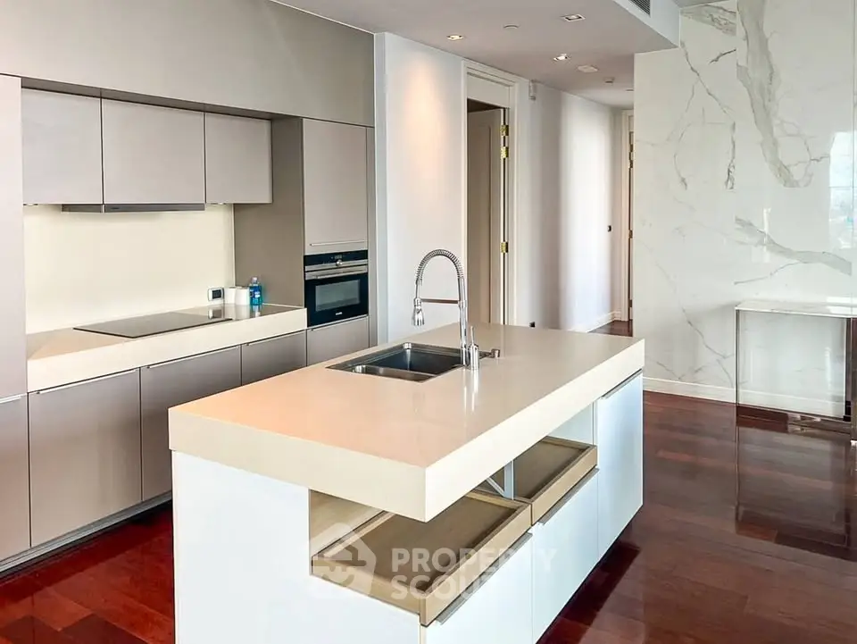 Luxurious modern kitchen with sleek cabinetry and spacious island in high-end apartment.