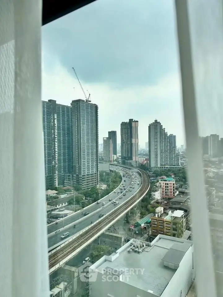 Stunning cityscape view from high-rise window showcasing urban skyline and highway.