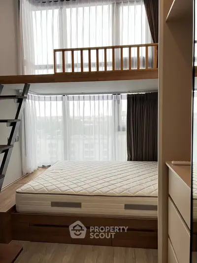 Modern bedroom with loft bed and large windows, maximizing natural light and space efficiency.