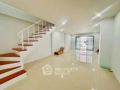Spacious modern living room with sleek staircase and glossy tiled floor