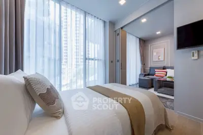 Modern bedroom with large windows and cozy living area in luxury apartment