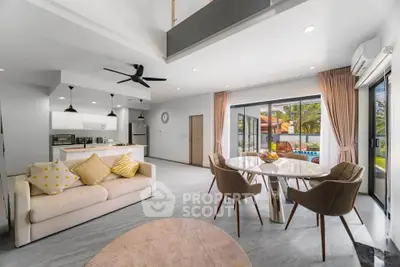 Spacious open-plan living room with modern kitchen and pool view, perfect for entertaining.
