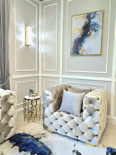 Luxurious living room with plush armchair, elegant wall art, and stylish side table in a sophisticated setting.