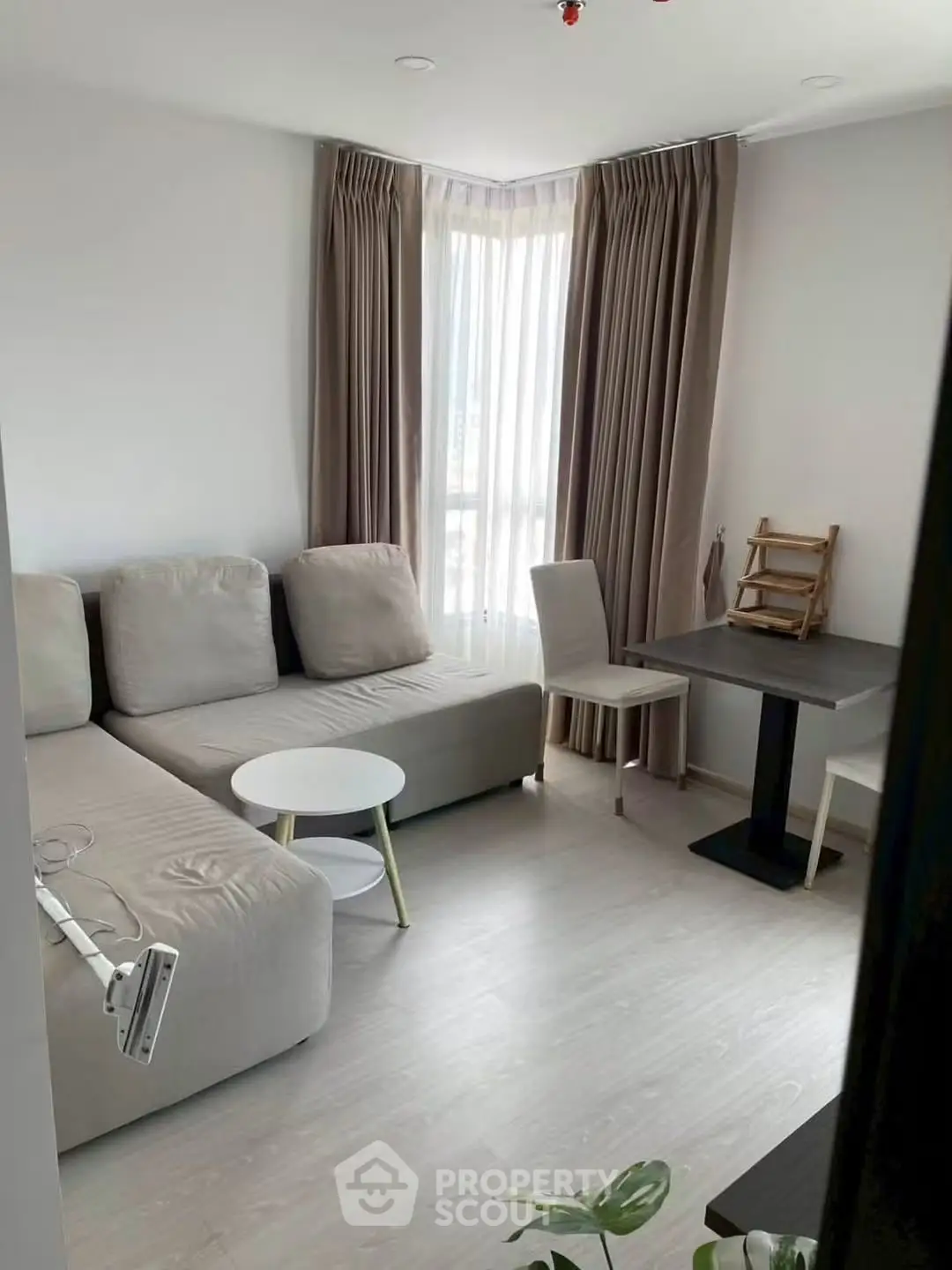Modern living room with cozy sectional sofa and dining area in bright apartment.