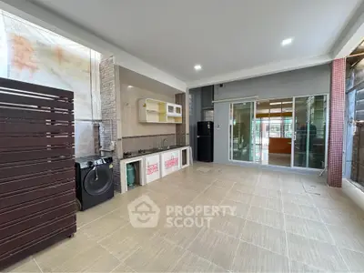 Spacious modern kitchen with open layout and washing machine, perfect for family gatherings.