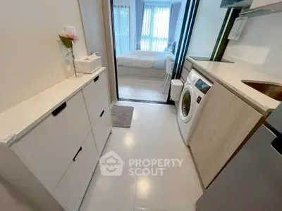 Modern apartment interior with compact kitchen and washing machine