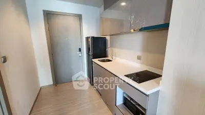 Modern compact kitchen with sleek cabinetry and built-in appliances in a stylish apartment.