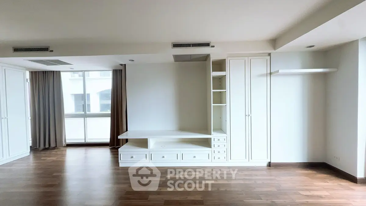Spacious modern living room with built-in storage and large windows