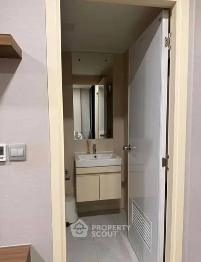 Modern bathroom with sleek vanity and mirror in a contemporary apartment.
