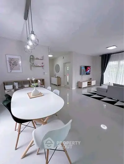Modern living room with sleek dining area and stylish decor, featuring contemporary furniture and bright natural lighting.