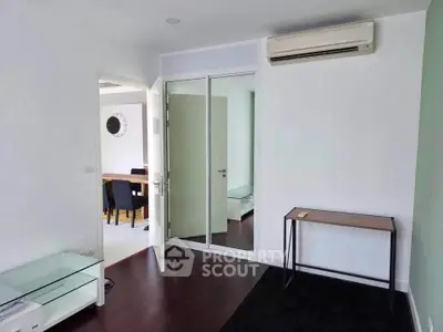 Modern interior with air conditioning and glass door, featuring sleek furniture and hardwood floors.