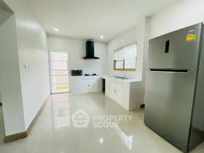 Modern kitchen with sleek appliances and open layout, featuring a stainless steel fridge and gas stove.