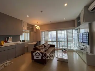 Modern living room with city view, featuring cozy sofa and sleek entertainment setup.