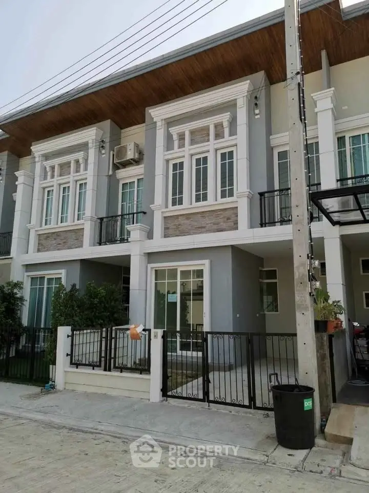 Modern townhouse exterior with stylish facade and gated entrance in a suburban neighborhood.