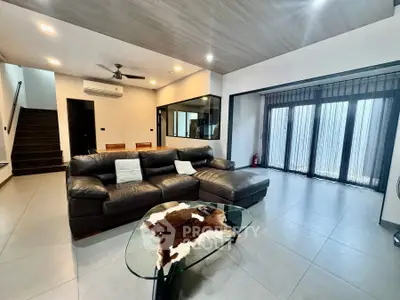 Spacious modern living room with leather sofa and glass coffee table