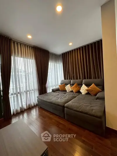 Spacious living room with elegant curtains and cozy sectional sofa