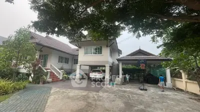 Charming suburban home with spacious driveway and lush greenery, perfect for family living.