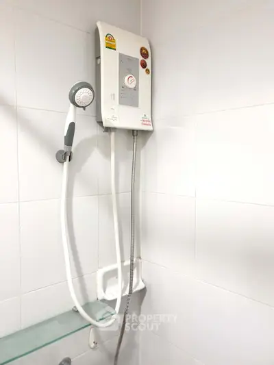 Modern bathroom with electric water heater and sleek white tiles.