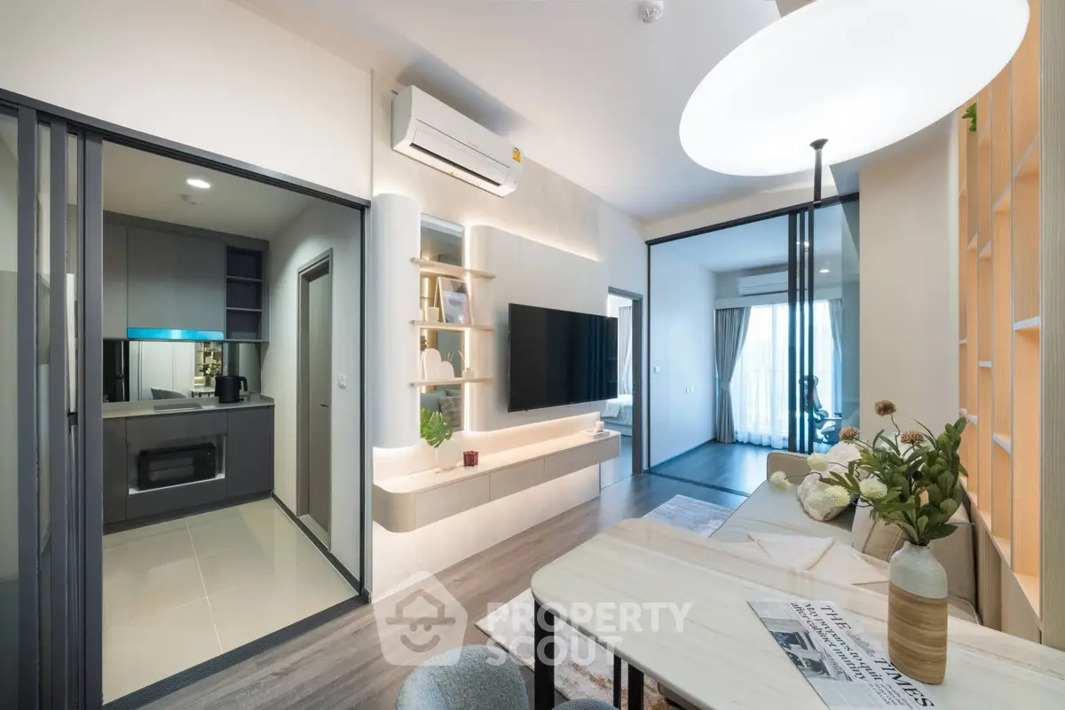 Modern open-plan living room with sleek kitchen and stylish decor in a contemporary apartment.