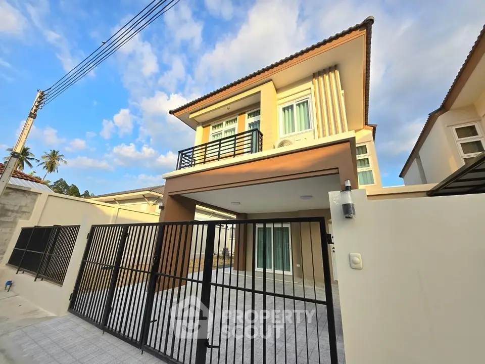 Modern two-story house with gated entrance and spacious driveway under a clear blue sky.