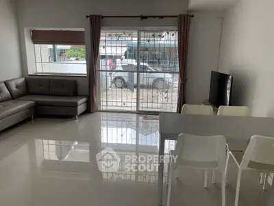 Spacious living room with modern furniture and large window offering natural light.