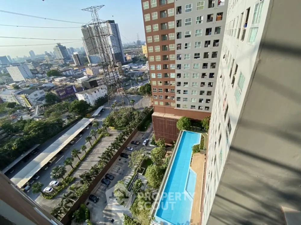 High-rise building with pool and city view from balcony, showcasing urban living.