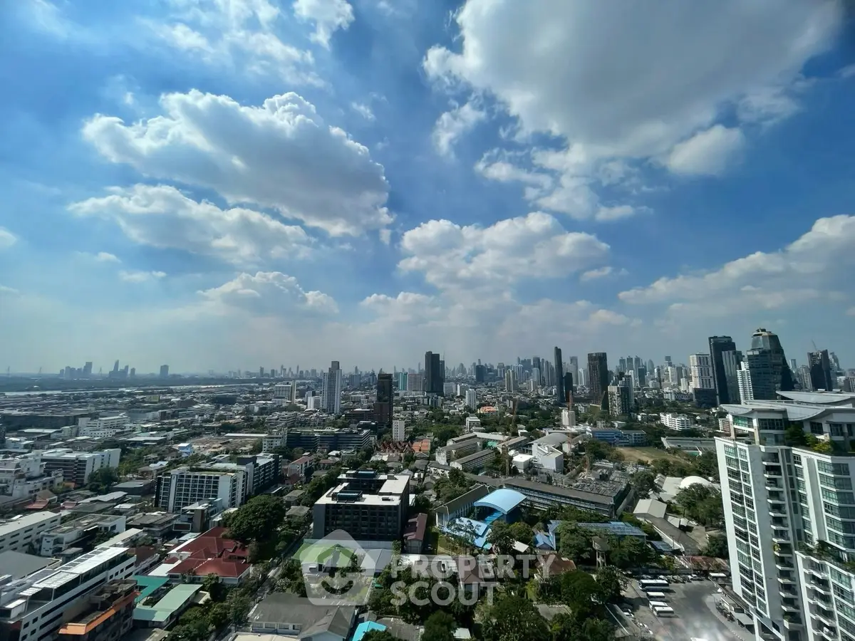Stunning cityscape view from high-rise building showcasing urban skyline under a vibrant blue sky.